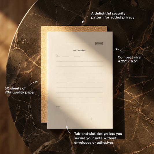 Notebook with security pattern on cover, text detailing features, on a marble surface.