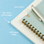Notebook with spiral binding and pen notch on a blue background