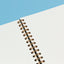 Spiral-bound notebook on a blue and white background