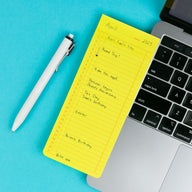 Monthly List Sticky Memo Pad Yellow on a laptop