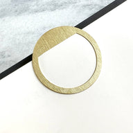 circle shaped brass page marker shown on a page in a notebook