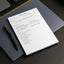 Notebook with an action plan on a dark surface with a pen next to it