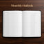 An open monthly outlook planner on a dark wood background, with the text 'Monthly Outlook' written above it. The pages are white with a minimalist grid layout for January 2027.