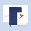 Navy blue planner with a stand featuring a calendar and illustration of a green bird on a light blue background.