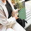 Person holding a one on one spiral-bound notebook outdoors