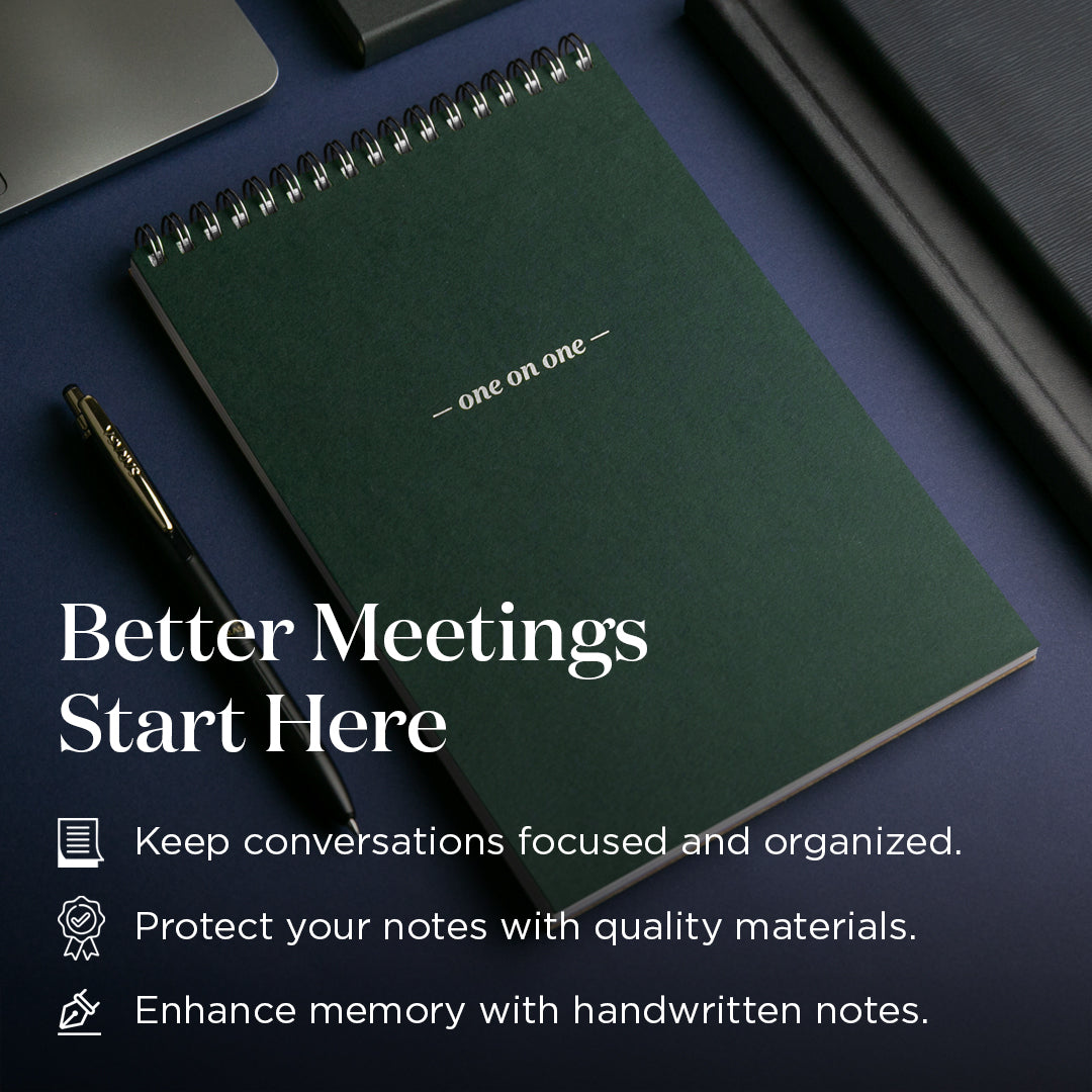 Green notebook with a pen on a dark surface, featuring text about better meetings and quality materials.