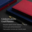 Limited Edition Goal Planner with red and blue covers on a dark surface, featuring a pen.